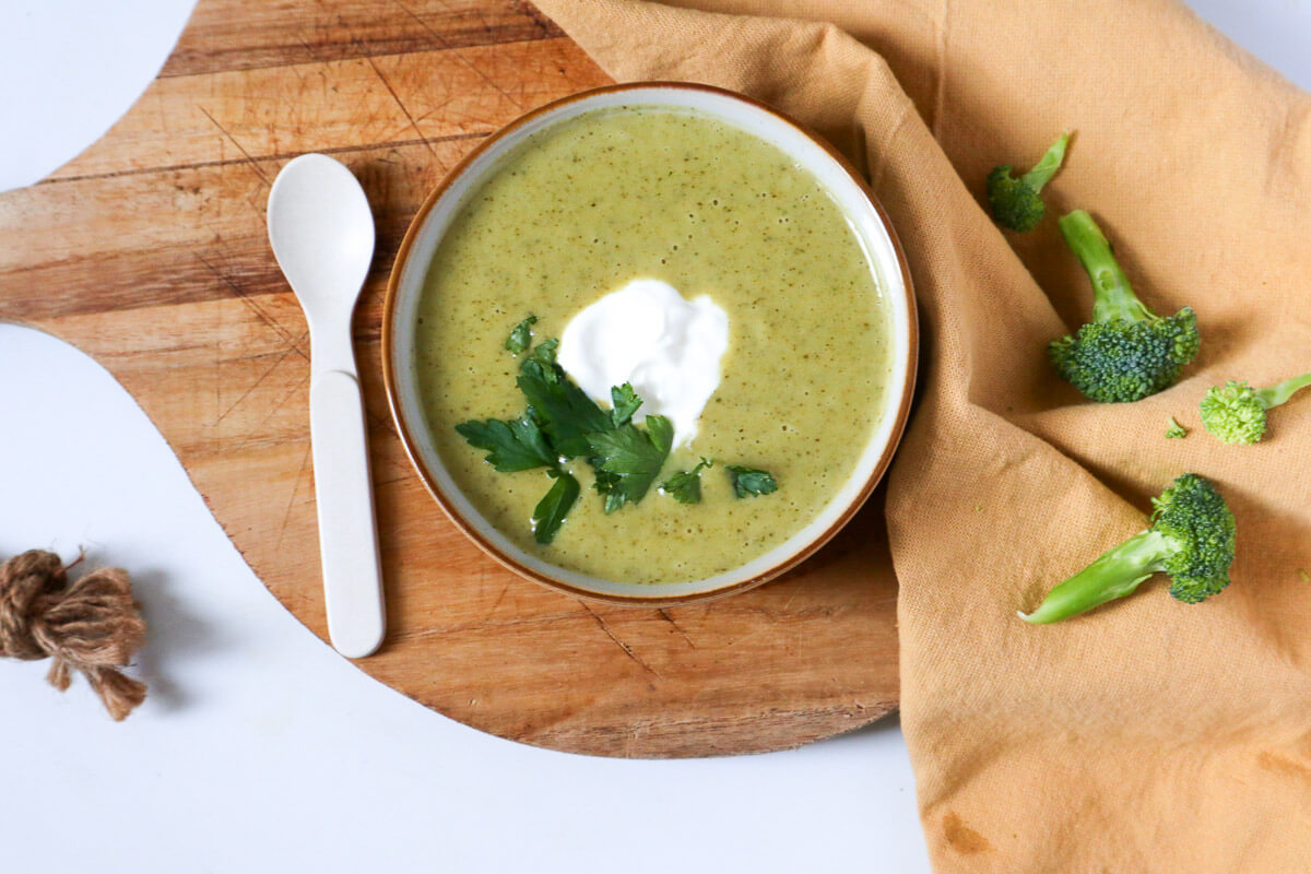 Creamy Vegan Broccoli Soup in a bowl with a spoon next to it. 