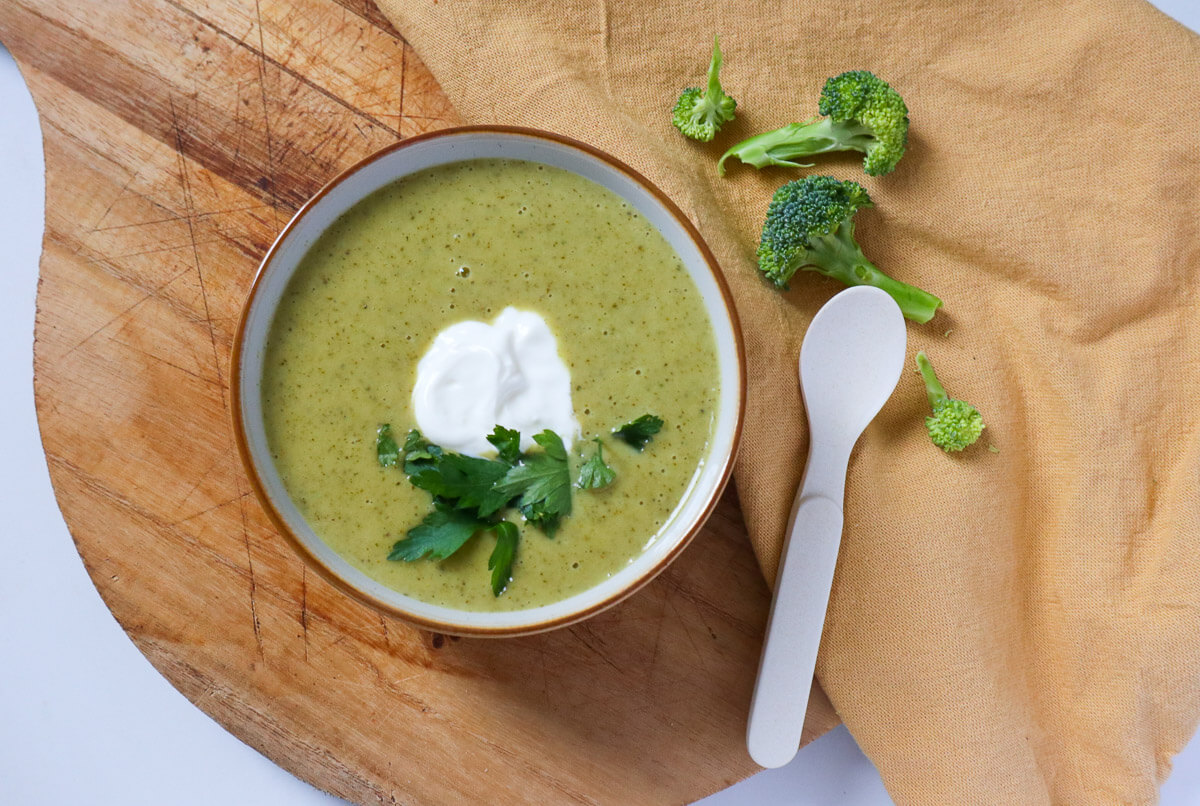 Creamy Vegan Broccoli Soup in a bowl with a spoon next to it.