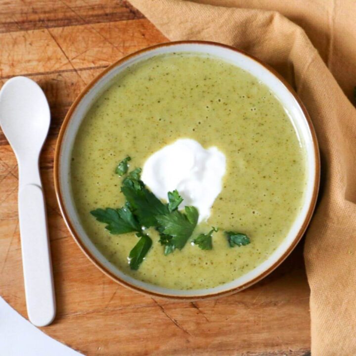 Creamy Vegan Broccoli Soup in a bowl with a spoon next to it.