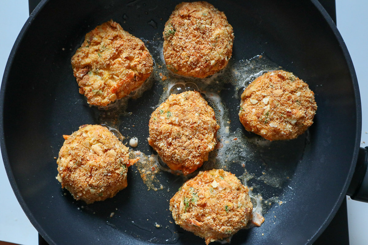 Frying raw chickpea patties on a pan