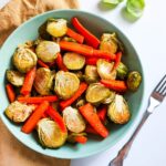 Lemon and garlic roasted carrots and brussel sprouts in a bowl.