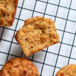 Halved pizza muffins on a cooling rack