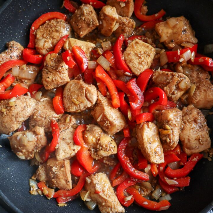 Salt and pepper chicken in a pan with peppers