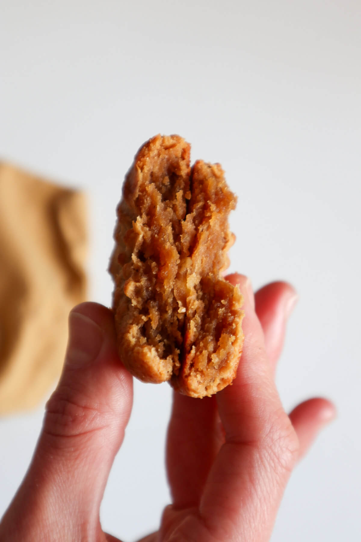 Halved cookie held by hands