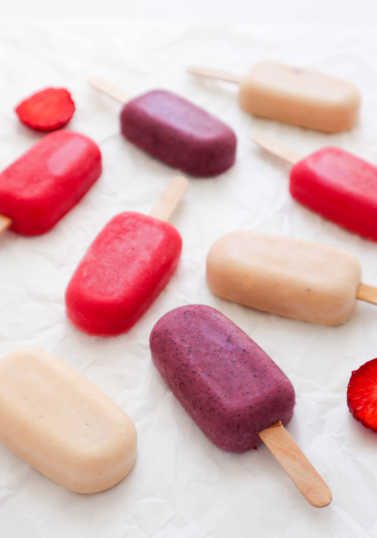 3 different colored yogurt popsicles on a white background