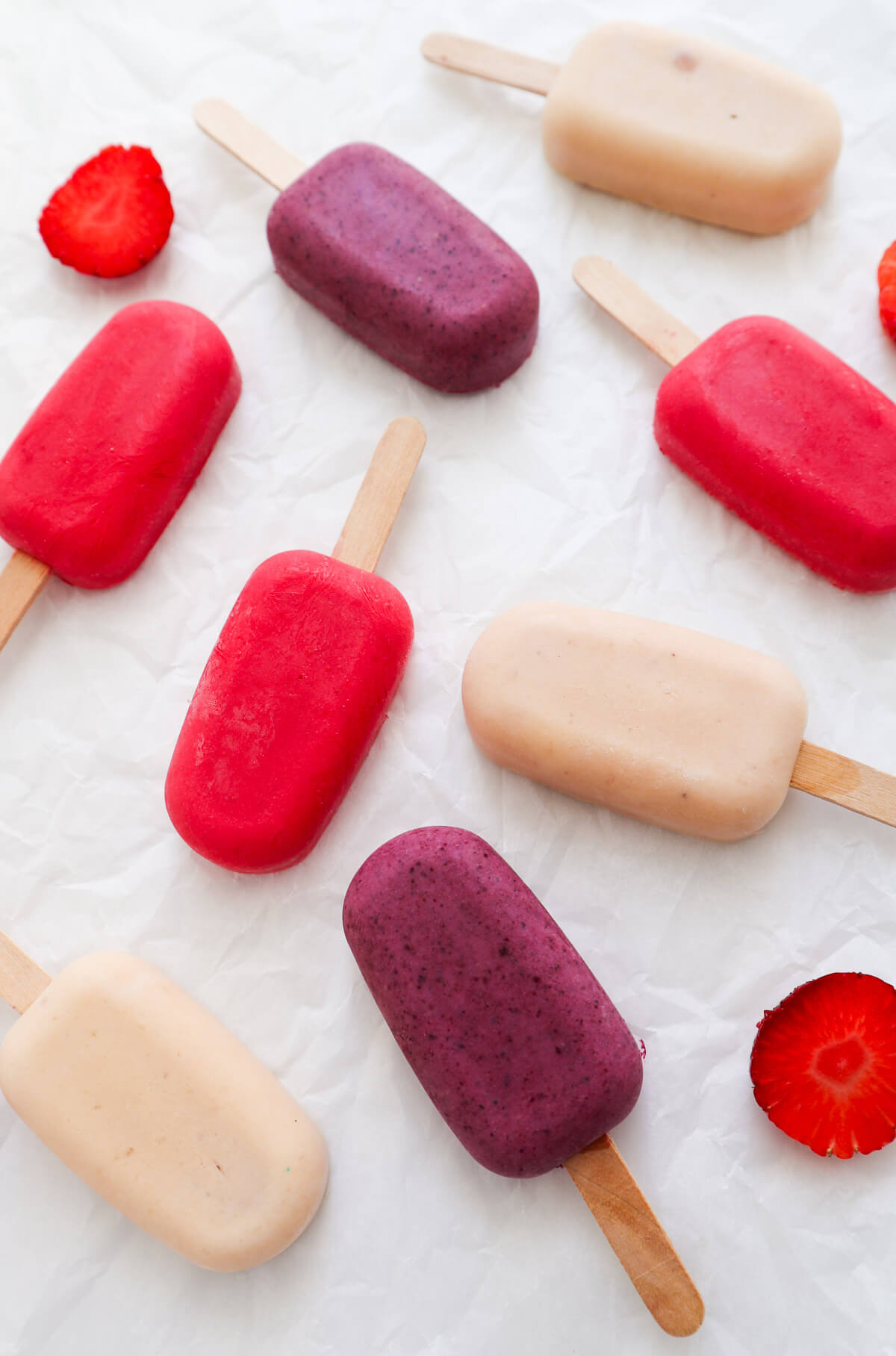 3 different colored yogurt popsicles on a white background