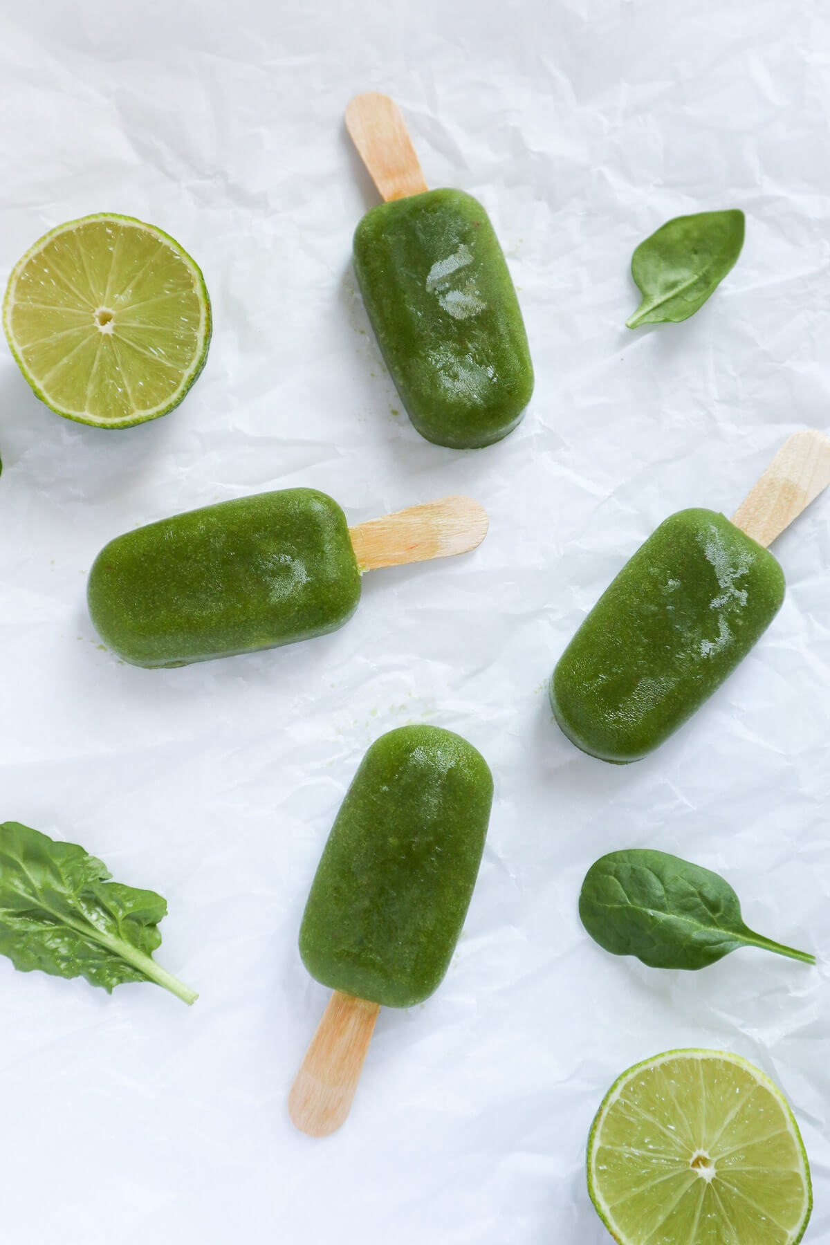 Green popsicles scattered on white background.