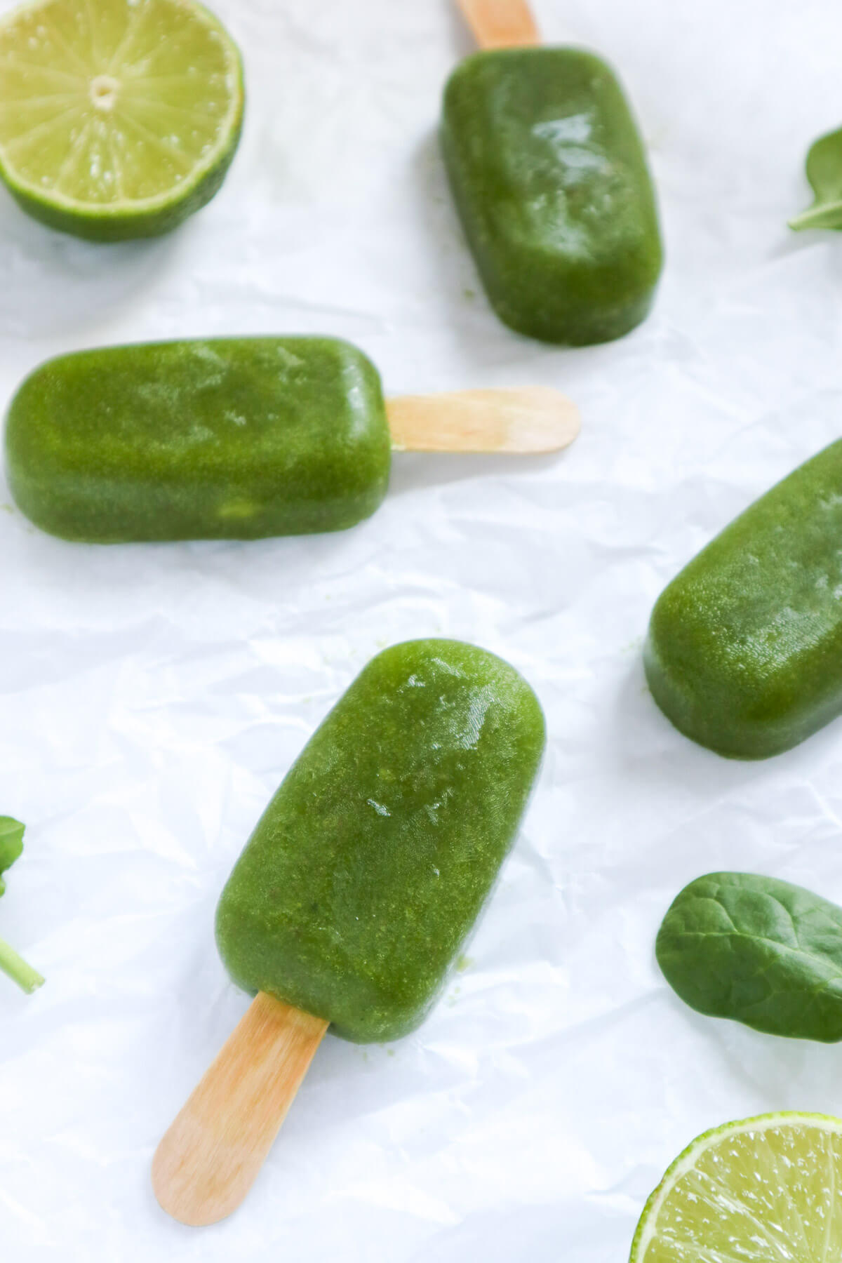 Green popsicles scattered on white background.