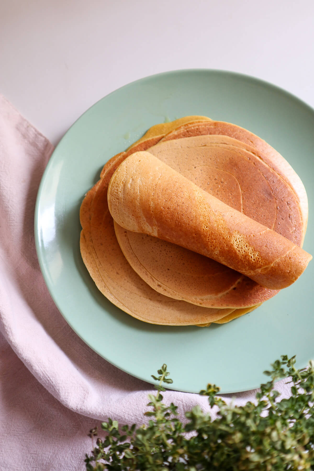 One rolled tortilla on top of a tortilla stack.