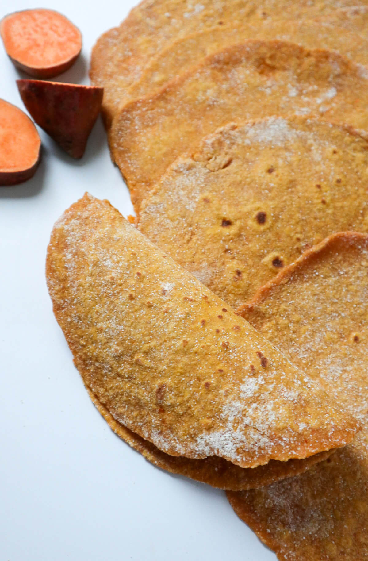 Sweet potato tortillas with one rolled up.